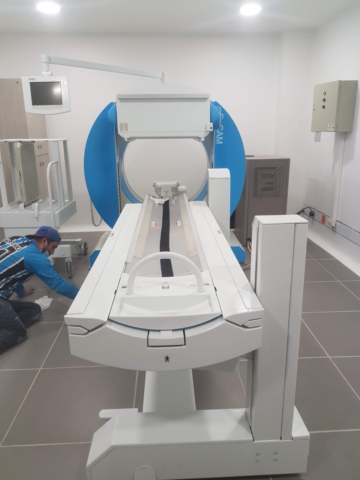 Instalación y puesta en marcha de gammacámara para medicina nuclear en sala blindada con técnico ajustando parámetros mecánicos